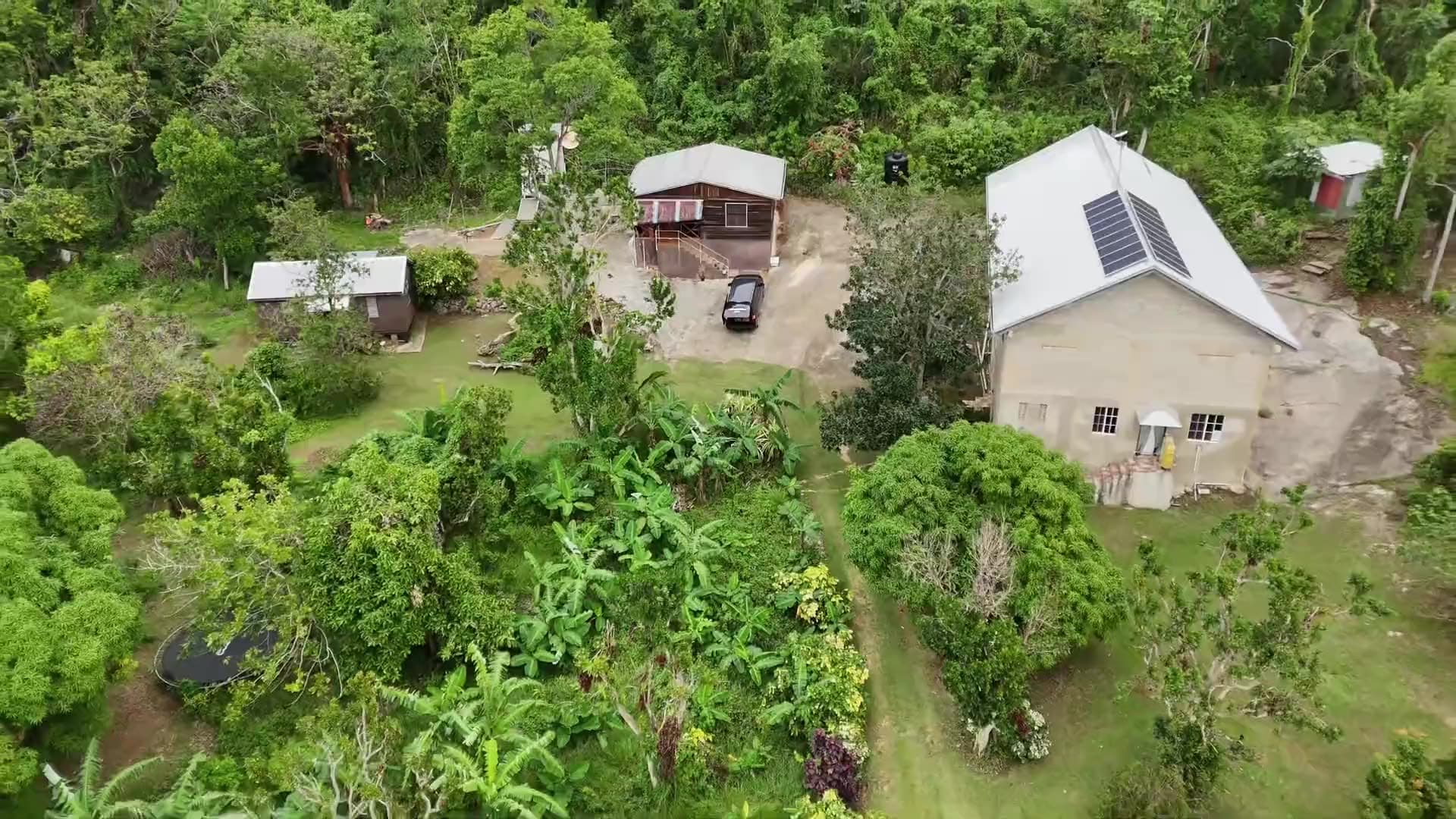 Aerial view of The Prayer Mountain's buildings and gardens, surrounded by forest